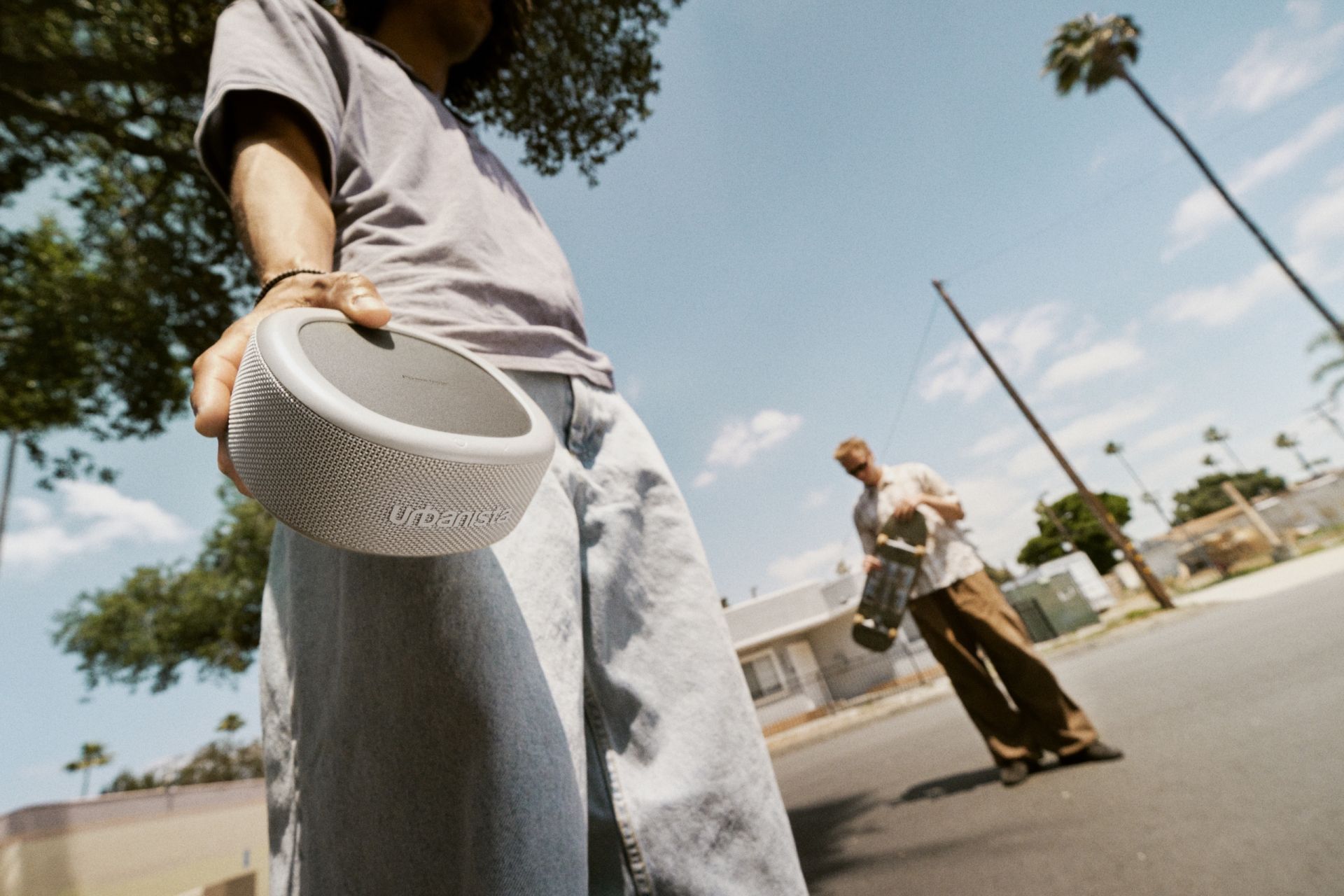 Skater holding an Urbanista Malibu solar powered portable speaker with Powerfoyle solar cell 